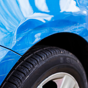 close up of a blue car showing a dent near the wheel tire damage four auto repair tips