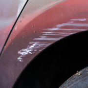 scratched car fender with damage showing repair needed for minor dents and scratches