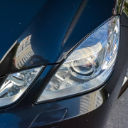 close up of a car headlight reflecting buildings with a shiny black exterior showcasing modern car design and technology 4 headlights