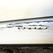 scratched white car door showing damage with exposed metal two types of damage on surface