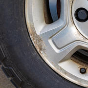 close up of a car wheel showing damage to the rim and tire five maintenance tips