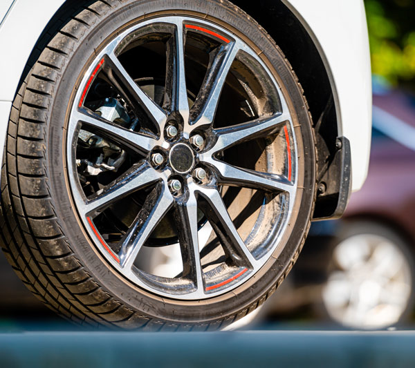 close-up of a stylish car wheel with chrome finish and red accents featuring a durable tire emphasizing 2 wheels on display