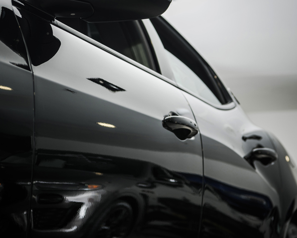 black car close-up with shiny surface reflecting light showcasing design elements and smooth lines featuring seven key details